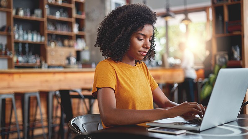 Woman sitting in a cafe working on a laptop